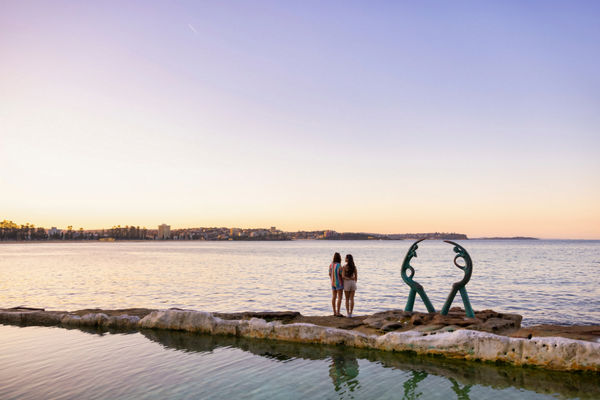 A couple enjoying the sunset at the Cabbage Tree Bay rock pool 