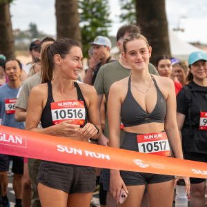 2 runners smile at start line of Sun Run