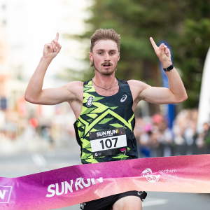 Male winner runs over finish line at Sun Run