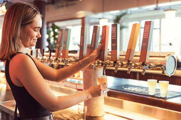 Bartender pours beer at Felons