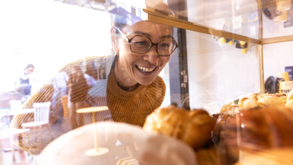Woman looks at pastries in a window display case
