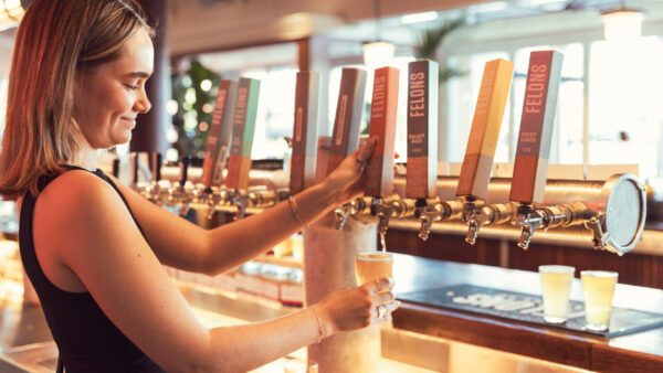 Bartender pours beer at Felons