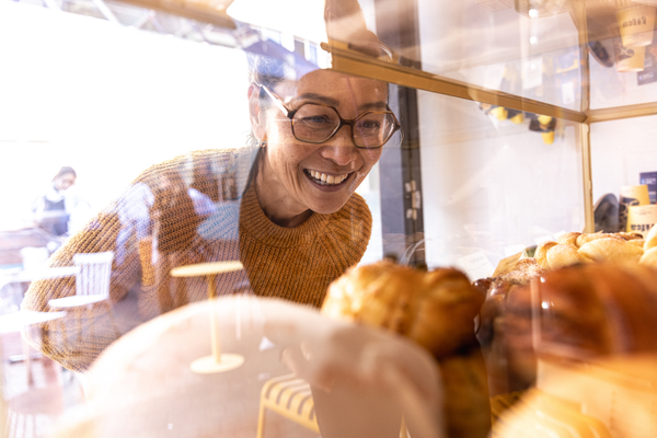 Woman looks at pastries in a window display case